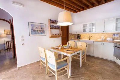 a kitchen and dining room with a table and chairs at Villa Thalassa Suites 3 Modern Comfort Traditional Greek Charm in Líndos