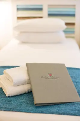 a laptop sitting on top of a bed with towels at Villa Thalassa 2 Cozy Greek Comfort Private Shaded Courtyard in Líndos