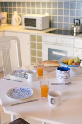 a table with plates and glasses of orange juice at Villa Thalassa 2 Cozy Greek Comfort Private Shaded Courtyard in Líndos