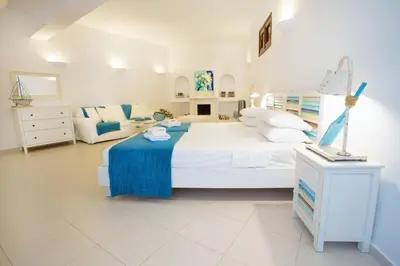 a white bedroom with a large bed and a couch at Villa Thalassa 2 Cozy Greek Comfort Private Shaded Courtyard in Líndos