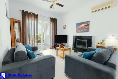 a living room with two blue couches and a fireplace at Executive Rhodes Villa Villa Gennadi 2 Bedroom Villa Private Pool & Sv in Gennadi