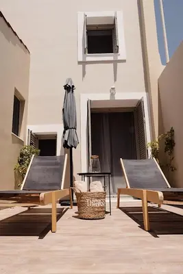 a patio with two chairs and an umbrella and a table at Casa di Famiglia Rhodes in Koskinou