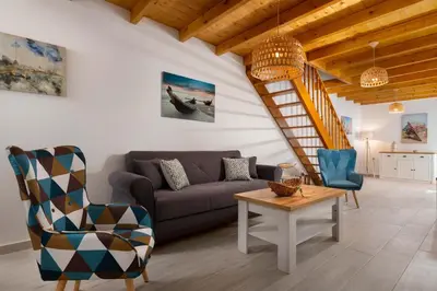 a living room with a couch and a staircase at Casa di Famiglia Rhodes in Koskinou