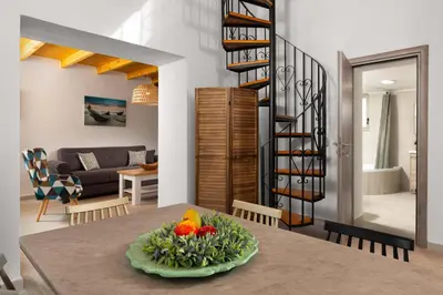 a kitchen and living room with a table with a bowl of fruit at Casa di Famiglia Rhodes in Koskinou