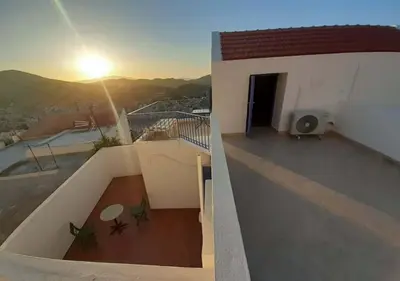 a view of a balcony of a house with the sunset at Symi Breeze villa in Symi