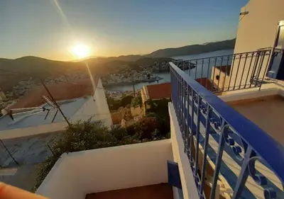 a view of the sunset from a balcony of a building at Symi Breeze villa in Symi