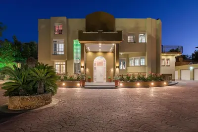 a large building with a front door with lights at Casa Loma in Triánta