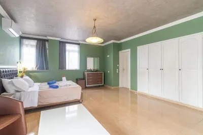 a bedroom with green walls and a bed and a couch at Casa Loma in Triánta