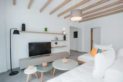 a living room with a white couch and tables at Terra Pietra Luxury Villas & Suites in Lardos