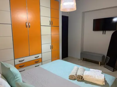 a bedroom with orange and white cabinets and towels on a bed at Villa Vergio in Afantou