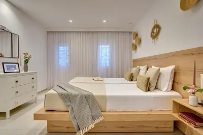 a bedroom with a large white bed and a dresser at Sia Mare Seaside Apartments in Faliraki