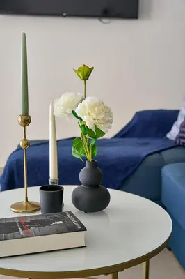a table with a vase with flowers and a book at Sia Mare Seaside Apartments in Faliraki