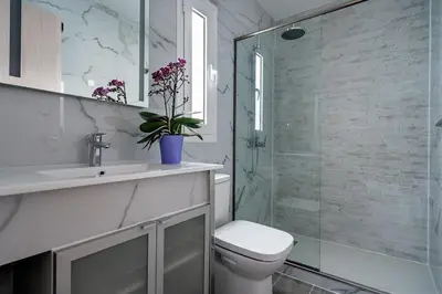 a bathroom with a toilet and a glass shower at Sia Mare Seaside Apartments in Faliraki