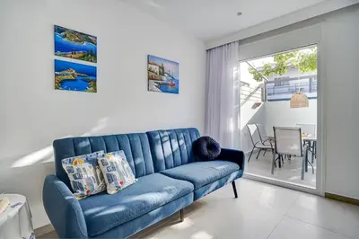 a blue couch in a living room with a table at Sia Mare Seaside Apartments in Faliraki