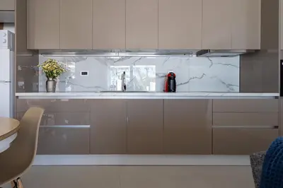 a kitchen with white cabinets and a sink at Sia Mare Seaside Apartments in Faliraki