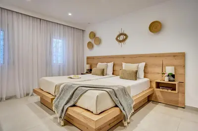 a bedroom with a large bed with a wooden headboard at Sia Mare Seaside Apartments in Faliraki