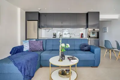 a living room with a blue couch and a table at Sia Mare Seaside Apartments in Faliraki