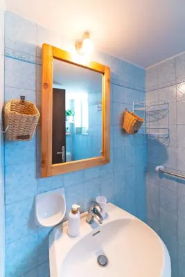 a bathroom with a white sink and a mirror at Tselios Apartments & Studios in Kiotari