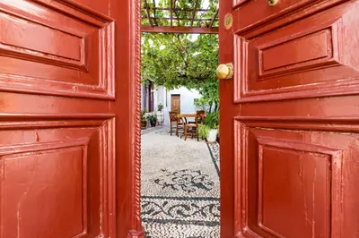 an open red door with a patio in the background at villa Zinovia in Líndos