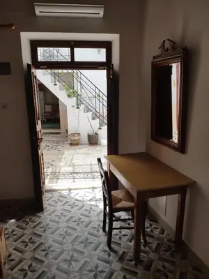 a table and chairs in a room with a staircase at villa Zinovia in Líndos