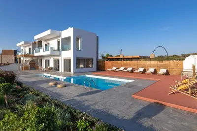 a house with a swimming pool in front of it at Anemos Villas in Lachania