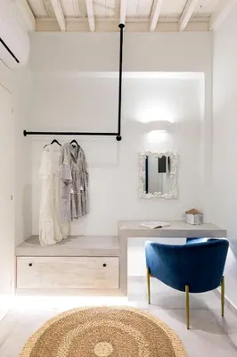 a room with a table and a blue chair at Thalassa Luxury Studios Lindos in Líndos
