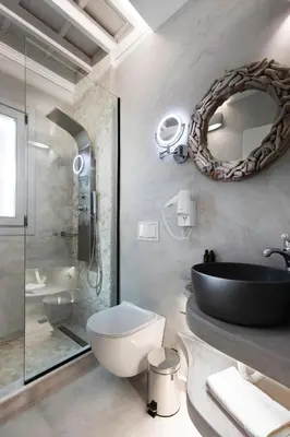 a bathroom with a sink and a toilet and a mirror at Thalassa Luxury Studios Lindos in Líndos