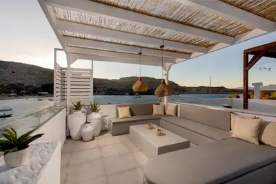 a patio with a couch and a view of the water at Thalassa Luxury Studios Lindos in Líndos