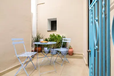 a table and chairs on a balcony with a table and chairs at Casa Plumeria of Old Town Rhodes in Rhodes Town