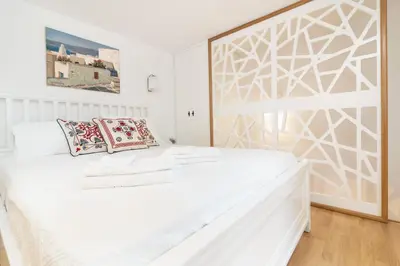 a white bedroom with a large white bed with pillows at Casa Plumeria of Old Town Rhodes in Rhodes Town