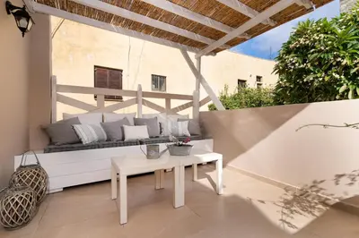 a patio with a white couch and a table at Casa Plumeria of Old Town Rhodes in Rhodes Town