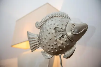 a metal fish statue sitting next to a lamp at Casa Plumeria of Old Town Rhodes in Rhodes Town