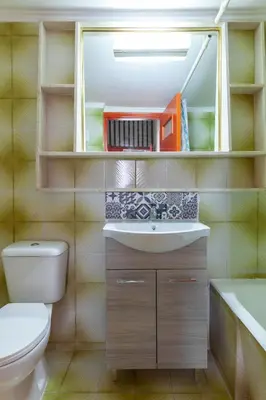 a bathroom with a toilet and a sink and a mirror at CHAMBRE ORANGE in Ialyssos