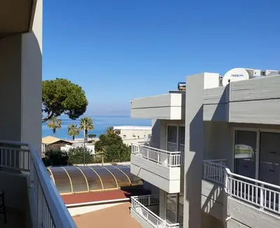 a view of a building with the ocean in the background at BLUE EYES APARTMENTS in Ixia