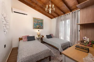 a living room with two beds and a chandelier at Aelia Sea View Bungalow in Gennadi