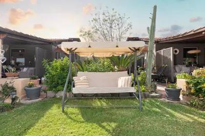 a garden with a white chair under an umbrella at Aelia Sea View Bungalow in Gennadi