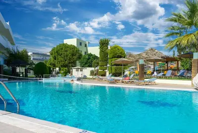 a large blue swimming pool with chairs and umbrellas at Stamos All Inclusive in Faliraki