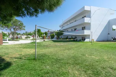 a building with a net in the grass at Stamos All Inclusive in Faliraki