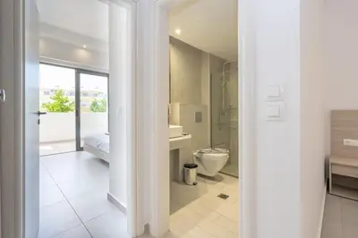 a white bathroom with a toilet and a shower at Stamos All Inclusive in Faliraki