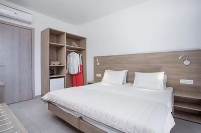 a bedroom with a large white bed and a closet at Stamos All Inclusive in Faliraki