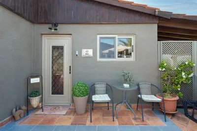 a patio with chairs and a table and a door at Ilaira Sea View Bungalow in Gennadi