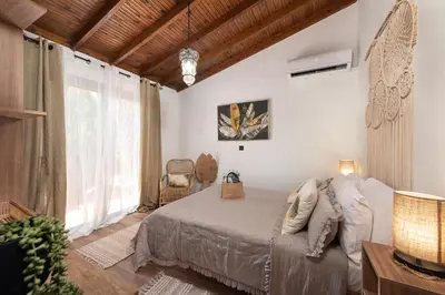 a bedroom with a bed and a large window at Ilaira Sea View Bungalow in Gennadi