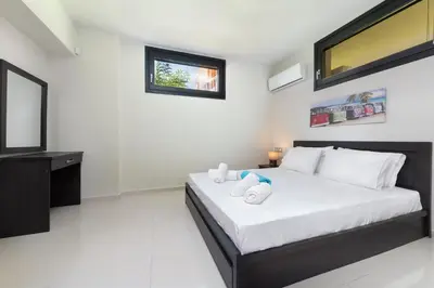 a white bedroom with a bed with two towels on it at Ixia Breeze 3 in Ixia