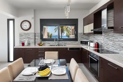 a kitchen with a dining table and a clock on the wall at Ixia Breeze 3 in Ixia