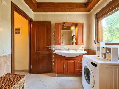 a bathroom with a sink and a washing machine at Colonial View Apartment in Faliraki