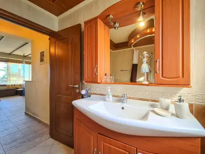 a bathroom with a white sink and a mirror at Colonial View Apartment in Faliraki