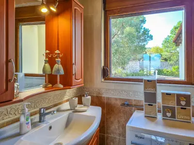 a bathroom with a sink and a window at Colonial View Apartment in Faliraki