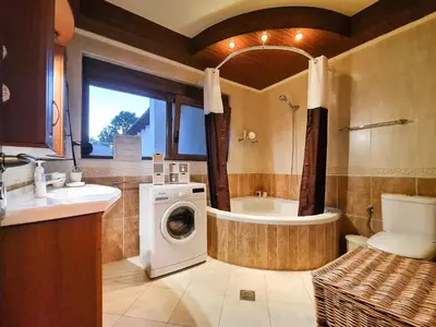 a bathroom with a washing machine and a bath tub at Colonial View Apartment in Faliraki