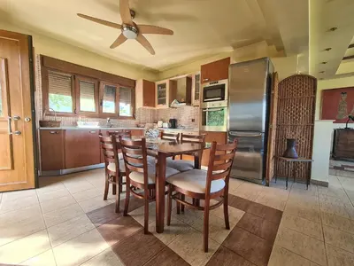 a kitchen with a table and chairs and a refrigerator at Colonial View Apartment in Faliraki