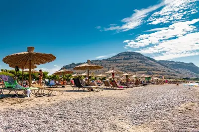 a group of beach chairs and umbrellas on a beach at Sun Beach Lindos in Lardos